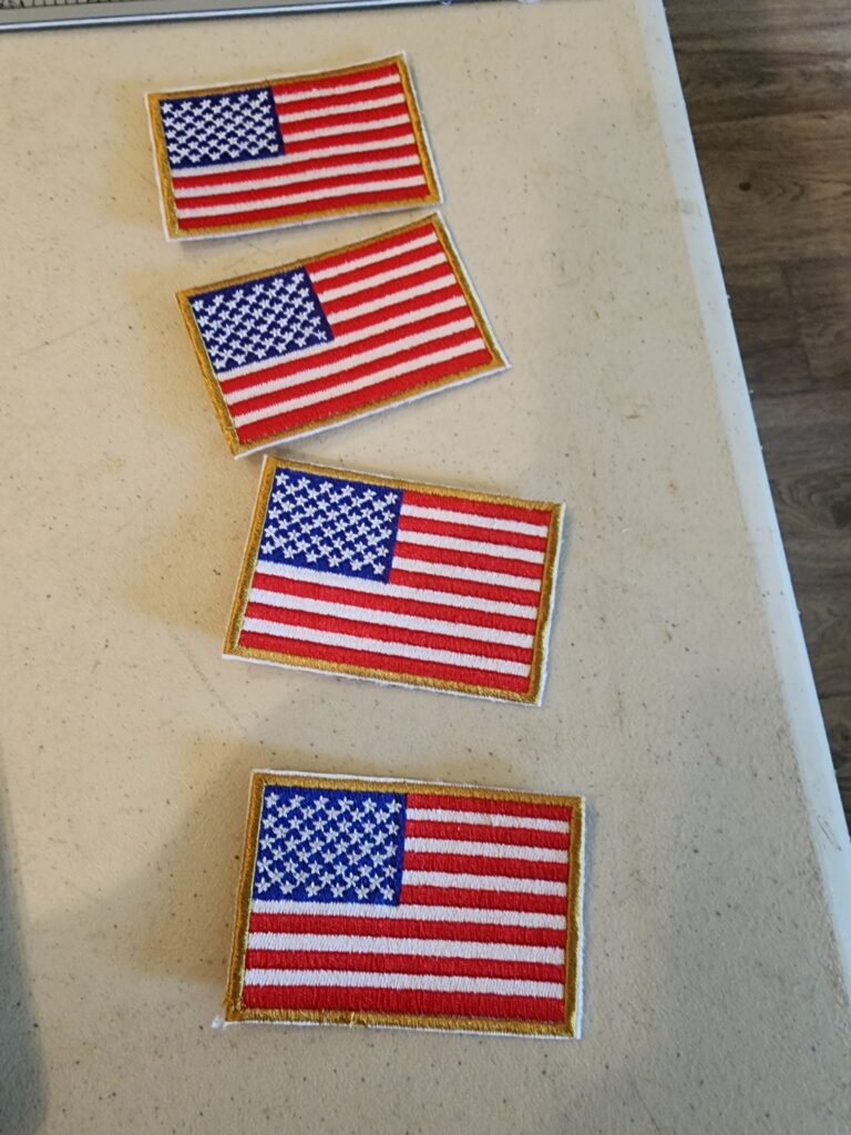 Four embroidered American flag patches on table